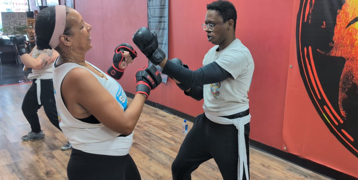 Man and woman practicing a gloved partner drill during an adult martial arts class at Tampa Wing Chun Kung Fu