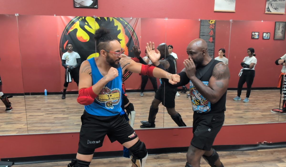 Two students demonstrating a close-range Wing Chun drill while the class watches at Tampa Wing Chun Kung Fu