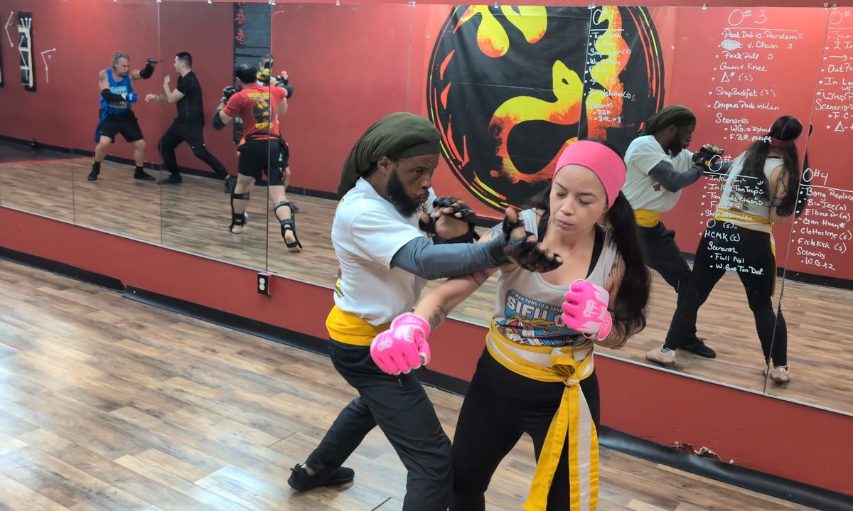 Man and woman practicing a Wing Chun partner drill in front of the mirror wall at Tampa Wing Chun Kung Fu